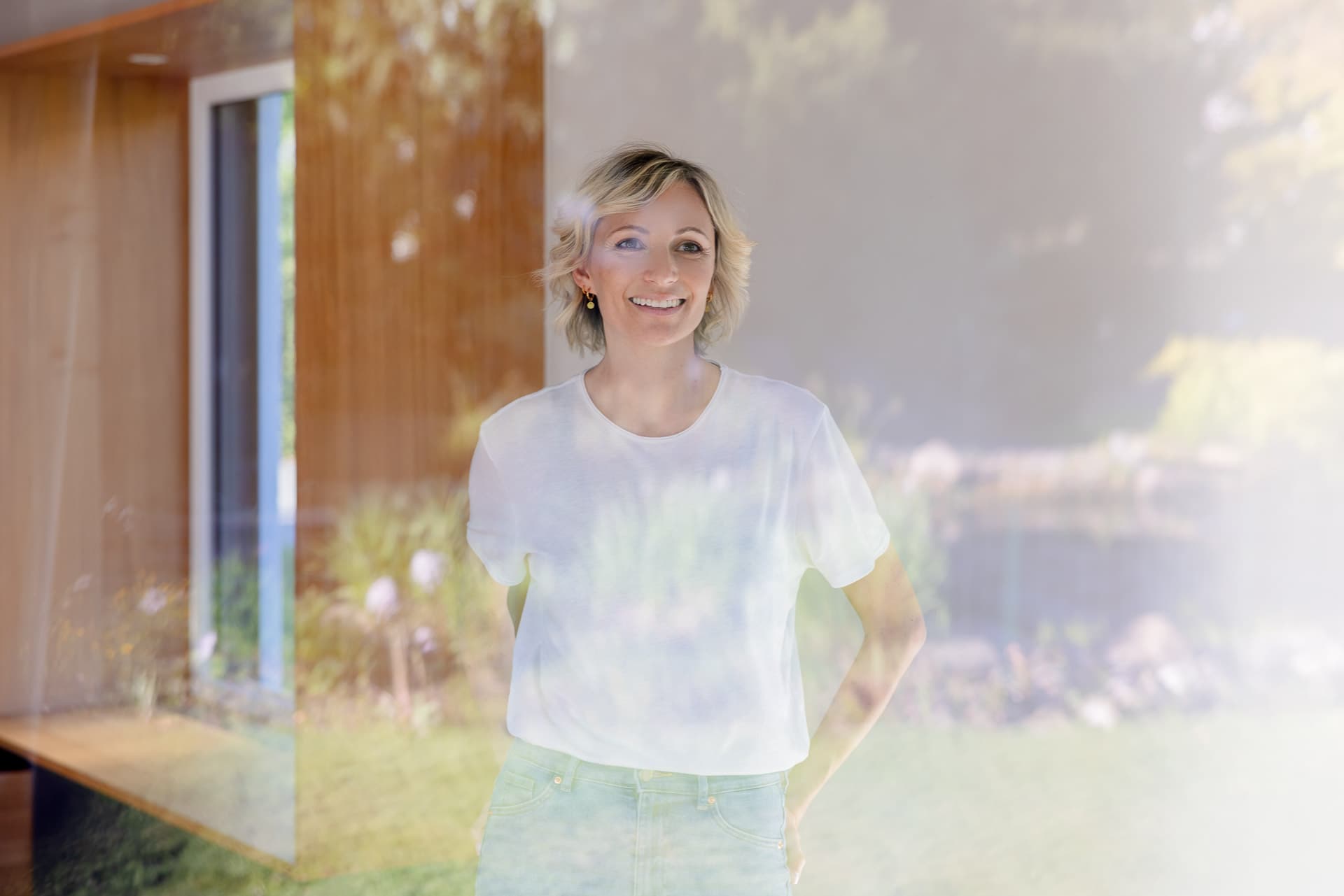 Kvinna står vid fönstret och funderar